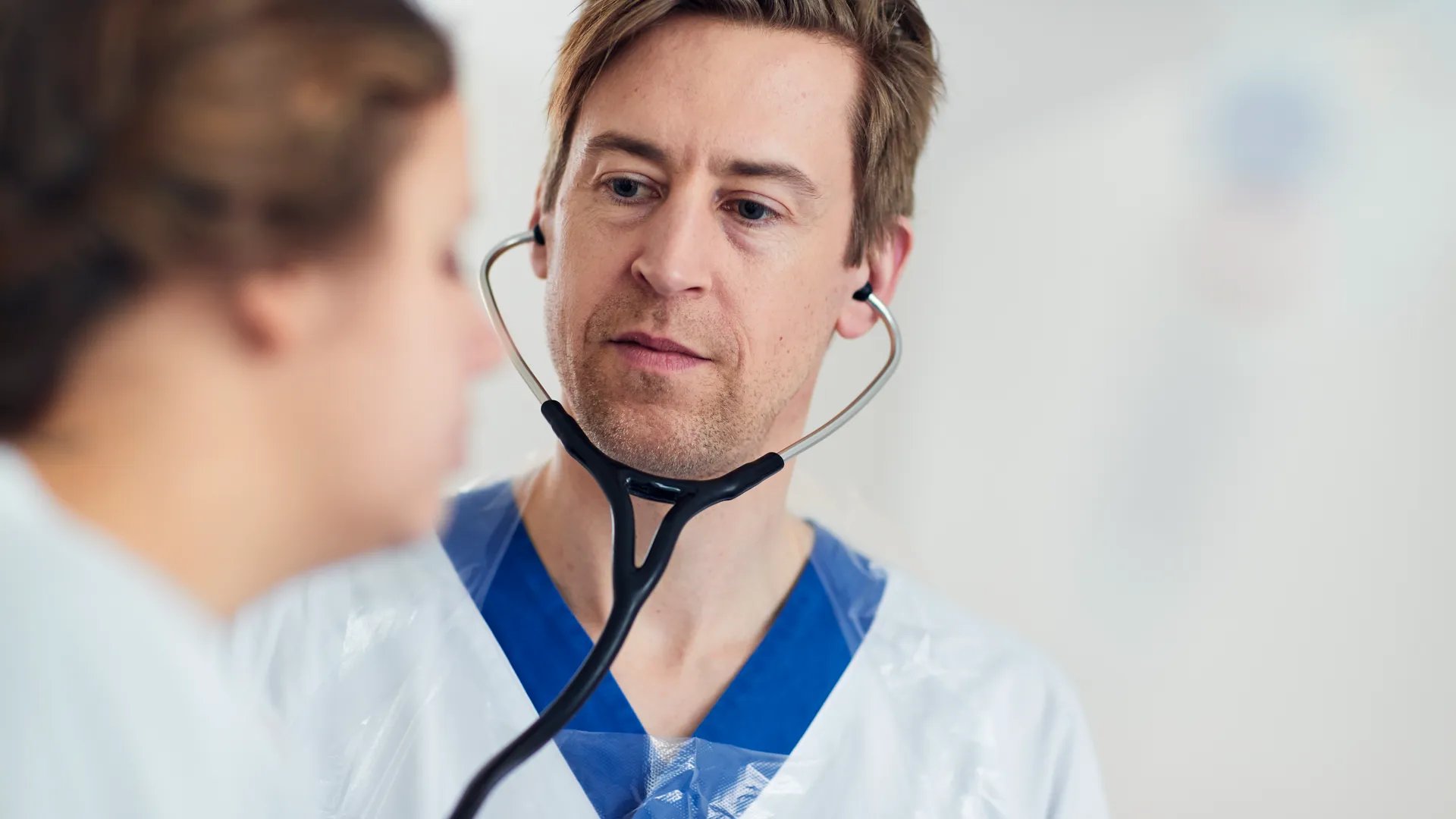 En läkare som pratar med en patient med ett stetoskop.